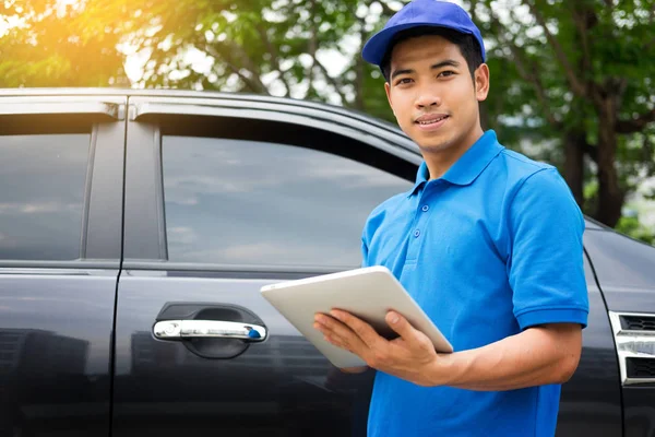 Delivery man checking document list on clipboard outdoor and Car