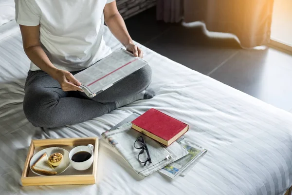 Wanita membaca buku atau koran dan minum kopi sarapan di — Stok Foto