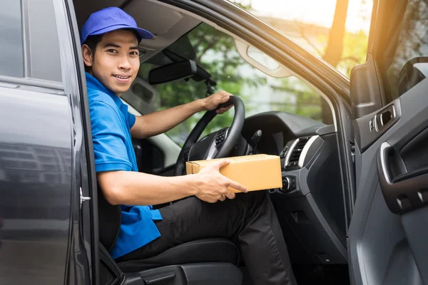 Levering messenger man met kartonnen doos buiten het magazijn — Stockfoto