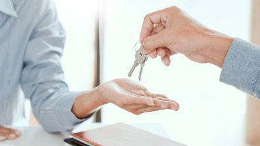 Ajan imzalanan anlaşmadan sonra ev anahtarlarını müşteriye veriyor