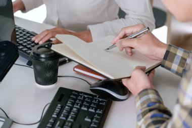 Masalarda oturan genç programcılar bilgisayarlar üzerinde çalışıyor 