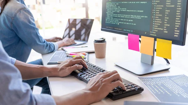 Jovens programadores de startup sentados em mesas trabalhando em computadores — Fotografia de Stock