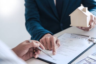 Emlakçılar gelen müşterilere belgeleri açıklar.