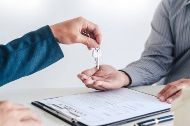 Emlakçılar gelen müşterilere belgeleri açıklar.