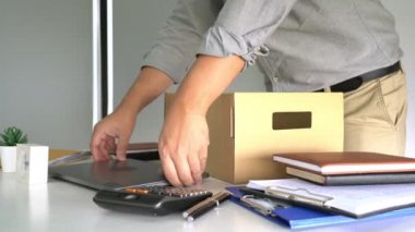 İş adamlarının kişisel eşyalarını ve dosyalarını toplayıp şirketten istifa, iş yerleştirme ve boş konsepti gibi kahverengi karton kutulara doldurduğu 4k video.