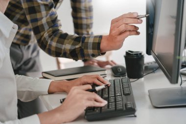 Masalarda oturan genç programcılar bilgisayarlar üzerinde çalışıyor 