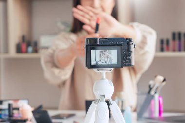 Güzel Asyalı kadın profesyonel güzellik vlog 'u veya blog yazarı kozmetik sunar ve video kaydı için ön kameraya makyaj uygular