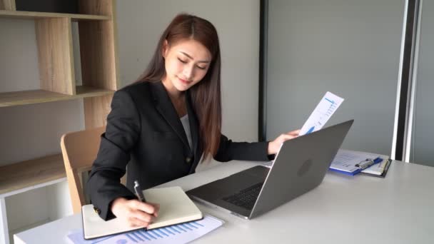 4K视频 专注的年轻漂亮的亚洲女人坐在写字台工作时使用笔记本电脑 — 图库视频影像