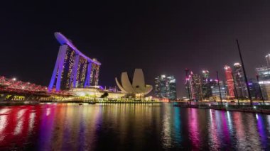 Singapore city, Singapore-  4 August 2019: 4K nighttime lapse video of Marina Bay Sands Luxury Hotel with urban buildings over water at the marina bay waterfront