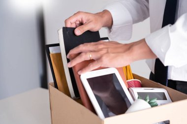 İş adamları istifa belgesi tutuyor ve şahsi şirketlerini kahverengi karton kutunun üzerine yerleştiriyor. İş değiştiriyor, istifa ediyor.