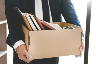 Üzgün Kovulan Genç İşadamları esrar fabrikası ve kişisel eşyalarla ilgili belgeler içeren kutular tutuyor. İşsizlik, istifa konsepti.