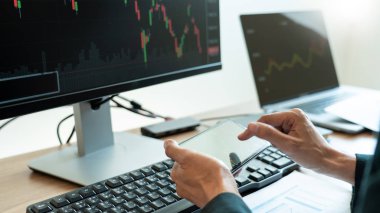 Yatırım amacıyla borsa grafiği ticareti amacıyla finans veri grafikleri ve raporlarını analiz eden işadamı komisyoncusu