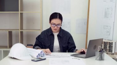 Ofisteki planlarla çalışan bir mimar. Ofiste çalışan mühendis, bina planı..