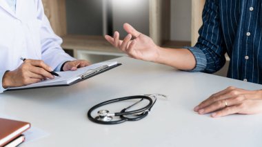 Doktor hasta ile çalışıyor, not alıyor ve sağlık, sağlık ve insan konsepti gibi konuları tartışıyor.