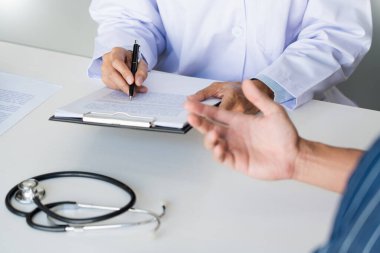 Doktor hasta ile çalışıyor, not alıyor ve sağlık, sağlık ve insan konsepti gibi konuları tartışıyor.