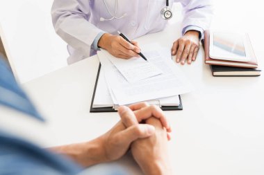 dikkatle dinliyor bir erkek hasta hasta belirtiler açıklayan veya onlar evrak tartışmak birlikte bir Danışma süreci gibi bir soru soran doktor