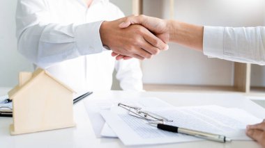 Ev müteahhitleri ve müşteriler mülkiyet hakkını devretmek için emlak satın alma veya kiralama sonrasında el sıkışıyor.