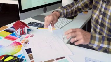 Tasarımcı ofisinde projesi üzerinde çalışıyor.