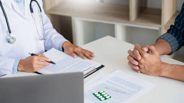 Médico Que Trabaja Con Paciente Tomando Notas Con Portapapeles Discutiendo — Foto de Stock