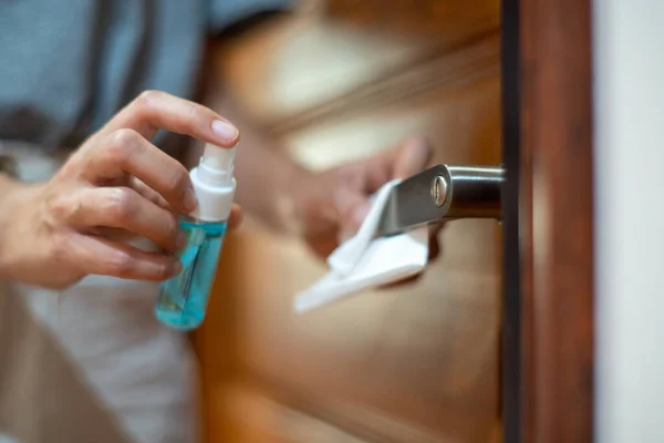 女用手在门把手上消毒 方法是从瓶中喷出蓝色清洁剂 用于Covid Coronavirus的预防 — 图库照片