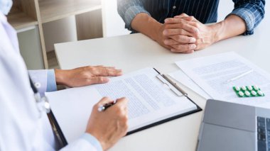 Doktor hasta ile çalışıyor, not alıyor ve sağlık, sağlık ve insan konsepti gibi konuları tartışıyor.