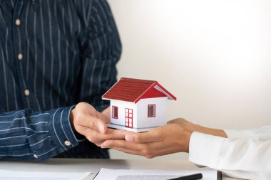 Ev müteahhitleri ve müşteriler anlaşmayı kabul ettikten sonra el sıkışıyorlar mülkiyet hakkının devredilmesi için emlak satın almayı veya kiralamayı bitirdiler