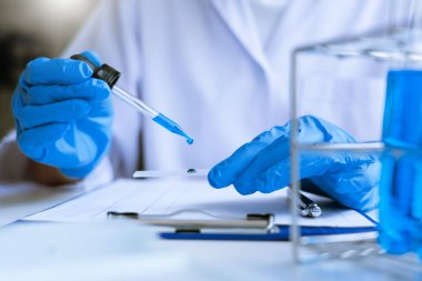 Bilim adamları laboratuvar önlüğü giyiyorlar ve koruyucu giysiler deney, laboratuvar ve geliştirme konseptinde deney tüpleriyle araştırma veya araştırma yapıyorlar..
