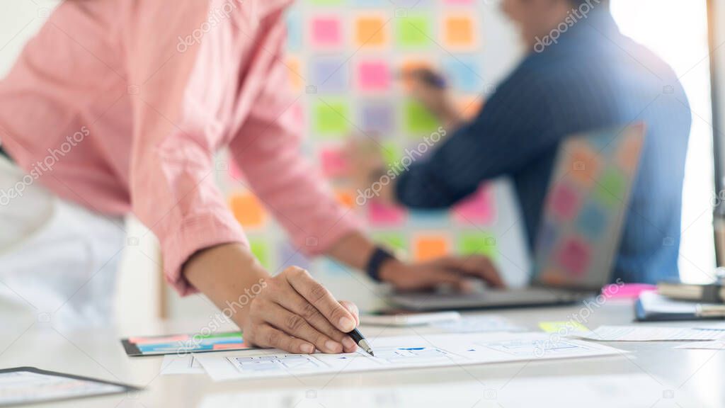 Graphic designers team work together with UX UI designer planning application template layout mobile phone prototype, User experience concept.