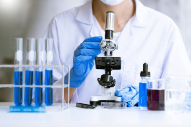 Mikroskop üzerinde çalışan, bilimsel deney yapan Asyalı Tıp Bilimadamı, Parlak Modern Laboratuvarda çalışıyor.