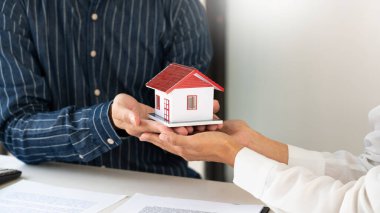 Ev müteahhitleri ve müşteriler anlaşmayı kabul ettikten sonra el sıkışıyorlar mülkiyet hakkının devredilmesi için emlak satın almayı veya kiralamayı bitirdiler