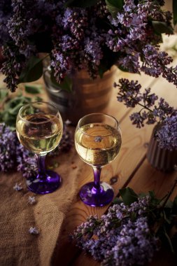 Çiçekli leylaklarla çevrili kadehler.