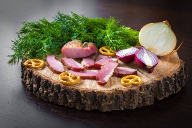 Füme pastırma bir ahşap tahta üzerinde otlar ile güdük