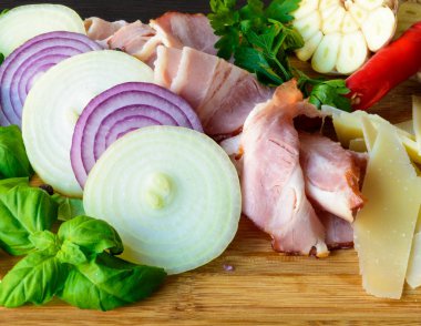 Soğan, sarımsak, peynir ve otlar ile ahşap tahta üzerinde ham pastırma füme dilimleri