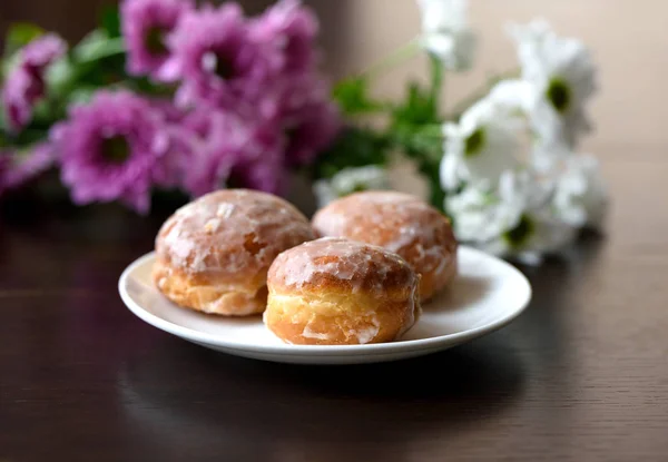 Donuts bir masaya çiçek ile — Stok fotoğraf