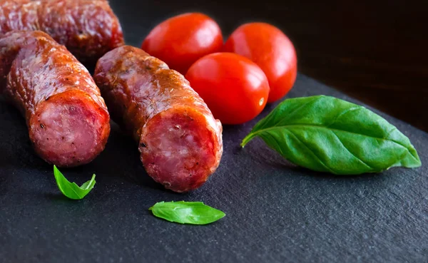 Жареная колбаса на темной доске — стоковое фото