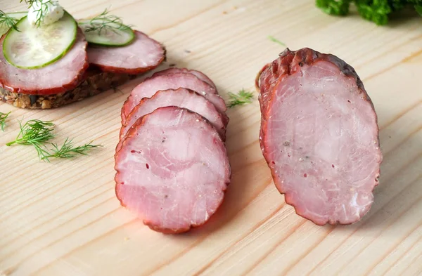 Salsicha fumada, presunto numa tábua de madeira — Fotografia de Stock