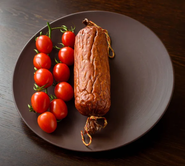 Smoked sausage with cherry tomatoes — Stock Photo, Image