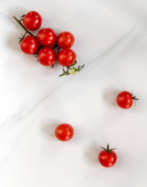Mermer bir tahtanın üzerinde kırmızı küçük domatesler