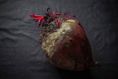 Taze yıkanmış pancarlar büyük boy siyah arka planda yatar.