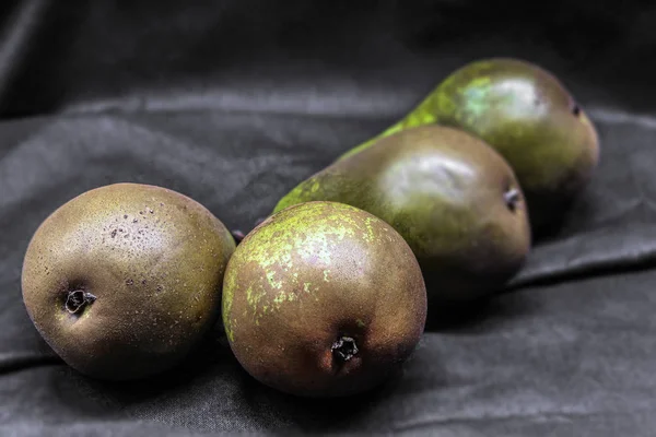 Fresh and healthy natural food lies on a black background. Pear varieties conference