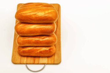 Yatay fotoğraf tahtanın üzerinde duran taze beyaz ekmeği gösteriyor.