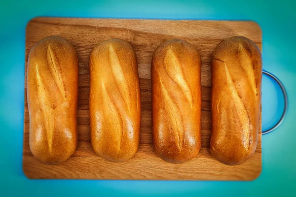 Pada Latar Belakang Biru Pada Papan Kayu Terletak Roti Putih — Stok Foto