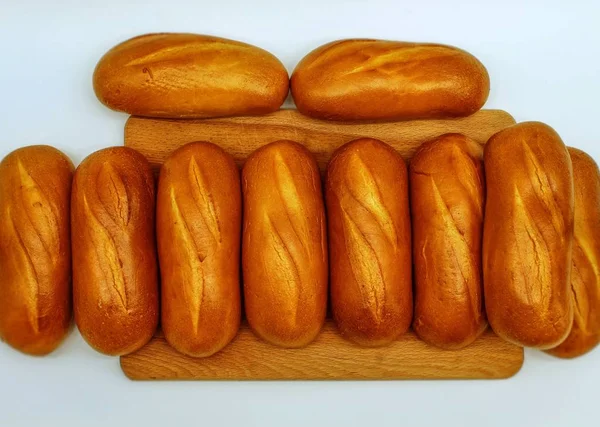 Dziesięć Małych Świeżych Bochenków Białego Chleba Leży Drewnianej Desce — Zdjęcie stockowe