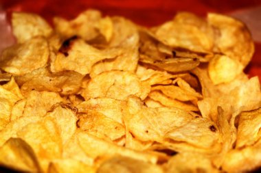 Fresh and crispy buttery potato chips close up on horizontal photo