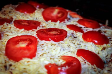 Peynirli ev yapımı taze pizza, kıyma, domates yakın planda gösteriliyor.