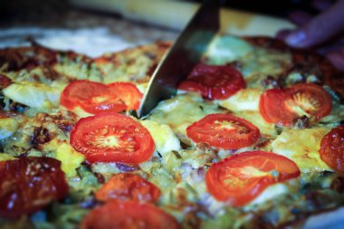 Bir kadın fırında pişirmek için yemek hazırlar. Peynirli pizza, haşlanmış tavuk yumurtası, et.