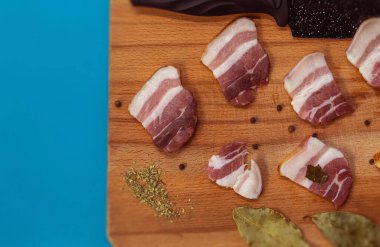 Tahtada yemek için et, et için baharat, körfez yaprağı ve karabiber var.