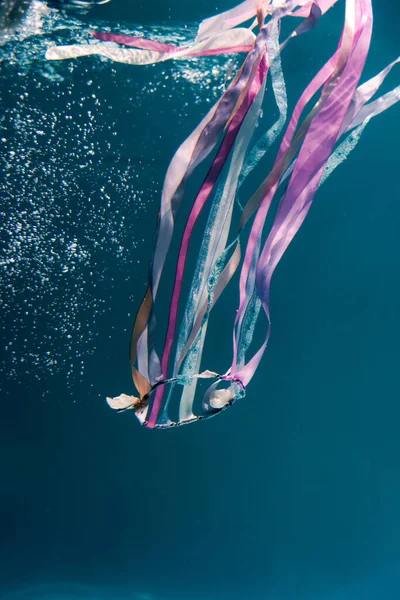 underwater photo of hair band with satin ribbons