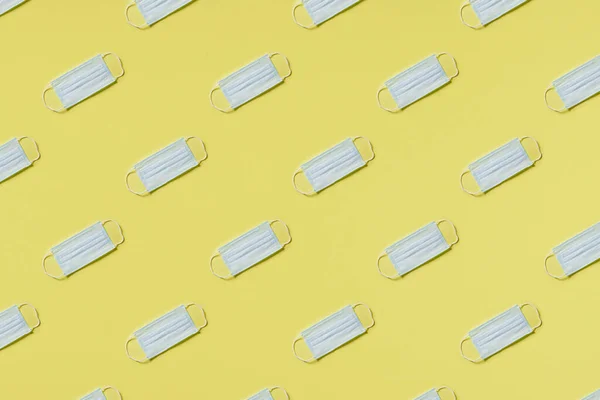 Pattern of medical mask on a yellow background. Hard light. Paper background