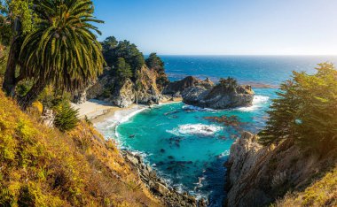 Meşhur Mcway Şelalesi doğal altın akşam ışık gün batımında klasik kartpostal görünümü güzel güneşli bir yaz, Julia Pfeiffer Burns State Park, Big Sur, California, ABD mavi gökyüzü ile